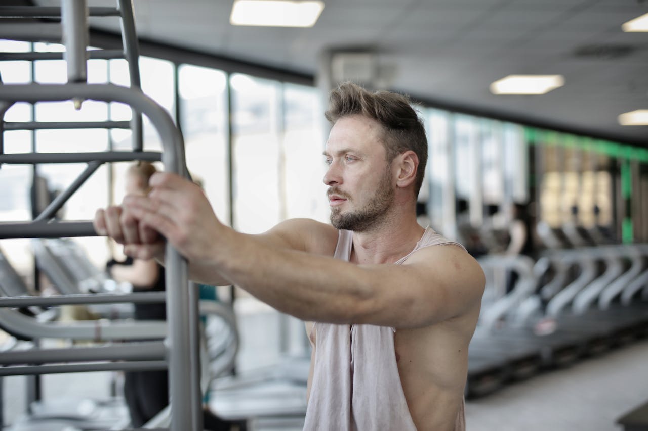 A man concentrating on his workout routine in a modern gym setting.